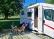 Two huskies with owner outside campervan at an Irish campsite